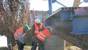 Foto von drei Männern, die an einer Brücke arbeiten