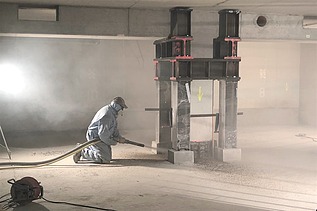 Foto von einer Person in Schutzausrüstung mit einer Spritzbetonlanze