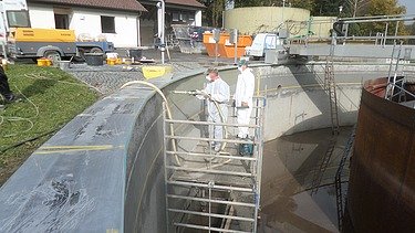 Foto von zwei Männern in Schutzkleidung auf einem Gerüst