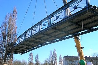 Foto von einer Brücke in der Luft, die von einem Kran angehoben wird