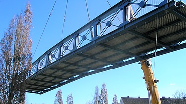 Foto von einer Brücke in der Luft, die von einem Kran angehoben wird